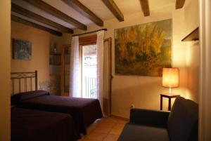 uma sala de estar com uma cama e uma janela em Casa de Pueblo El Patio de las Cebollas em Segorbe