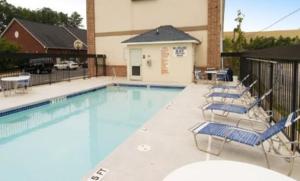 a swimming pool with lounge chairs and a building at Garden Inn Hotel in Union City