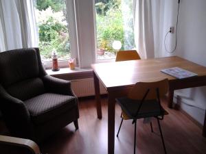 OostwoldにあるB&B Meerlandのテーブルと椅子、窓が備わる客室です。