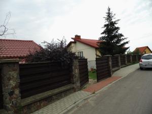 une clôture devant une maison avec une voiture dans l'établissement Kwatera do wynajęcia, à Gołdap