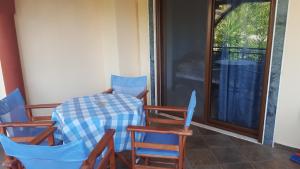 a table and chairs sitting on a porch at Petrino 2 by Vasileia in Sarti