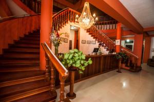 un vestíbulo con escaleras y una lámpara de araña en Hotel Cabaña Quinta, en Puerto Maldonado