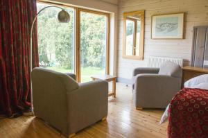 sala de estar con 2 sillas y ventana en Brathay Hall - Brathay Trust en Ambleside
