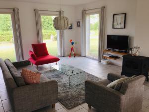 a living room with two couches and a tv at Les Vignes de Paris in Paris-lʼHôpital