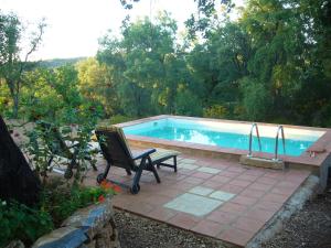 una piscina con sedia e panca accanto ad essa di Casas el Alamillo- el Castañero a Galaroza