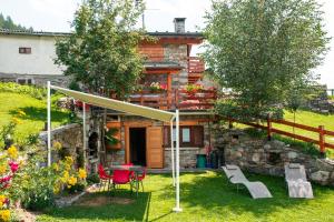 una casa con tavolo e sedie in cortile di Baita Carnale, Montagna in Valtellina a Cà Paini