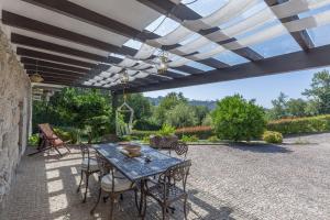 eine Terrasse mit einem Tisch und Stühlen unter Markise in der Unterkunft Boutique Country House w/ Pool by Host Wise in Travanca