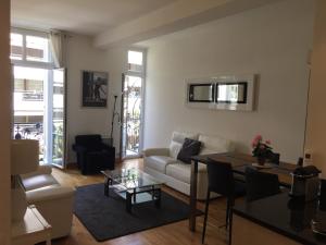 ein Wohnzimmer mit einem Sofa und einem Tisch in der Unterkunft Golden Triangle 2Br/2Ba in Cannes