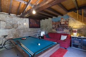 a room with a pool table and a red couch at Boutique Country House w/ Pool by Host Wise in Travanca