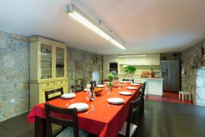 una cocina con una mesa de comedor larga con mantel rojo en Boutique Country House w/ Pool by Host Wise en Travanca