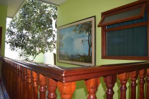 einen Balkon mit einer Holzschiene und einem Fenster in der Unterkunft Hotel Posada del Centro in Guatemala