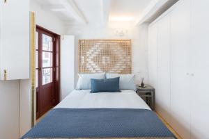 a bedroom with a large bed with blue pillows at Caldeireiros Porto Old Town Flat in Porto