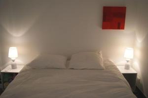 - une chambre avec un lit et 2 lampes sur les tables dans l'établissement Le Gîte de l'Océan, à Lège-Cap-Ferret