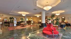 un hall avec une chaise rouge au milieu dans l'établissement Best Western Hotel Globus City, à Forlì