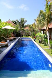 een groot blauw zwembad naast een resort bij Kaniya bali in Nusa Dua