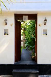 een open deur naar een gebouw met een pad bij Kaniya bali in Nusa Dua