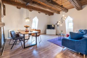 a living room with a table and chairs and a tv at Parkside Boutique Appartements in Herbolzheim