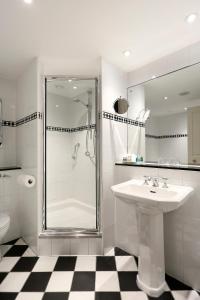 a white bathroom with a shower and a sink at Macdonald Berystede Hotel & Spa in Ascot