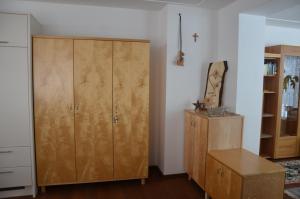 Zimmer mit einem großen Holzschrank und einem Tisch in der Unterkunft Appartement Nischler in Wald im Pinzgau