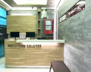 a reception counter with two computers on a wall at RIVERO BOUTIQUE HOTEL Seremban 2 in Seremban