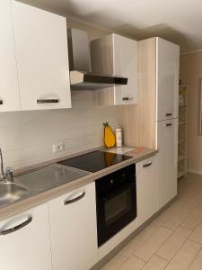 a kitchen with white cabinets and a stove top oven at Al Lago da Lilly in Gargnano