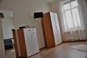 a room with a white cabinet and a window at L&R Apartment in Győr