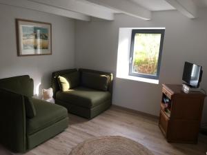 ein Wohnzimmer mit einem Sofa und einem Stuhl in der Unterkunft La Ferme des Potets in Fresse