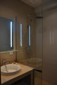 a bathroom with a sink and a glass shower at Burdigala Homes - Appart Duffour Dubergier in Bordeaux