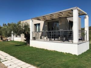 a house with a balcony with a table and chairs at Alikon Adult-Only in Neos Marmaras