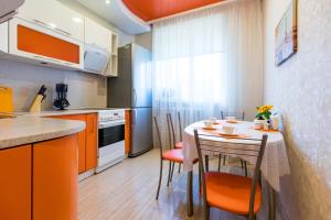 a kitchen with a table and chairs in a room at Five Stars Center City in Krasnoyarsk
