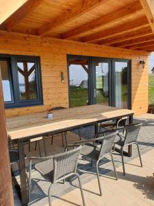 einen Holztisch und Stühle auf einer Terrasse in der Unterkunft Domek z widokiem na jezioro - Domek Jerzy in Kruklanki