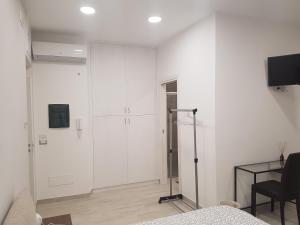 un soggiorno con pareti bianche e tavolo di Guest House Via Milano a Catanzaro Altre 16 foto