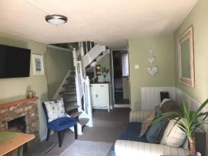 uma sala de estar com um sofá e uma escada em Ham Tree Cottage em Trowbridge