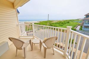 un balcón con 2 sillas, una mesa y el océano en Drifting Sands Oceanfront Hotel en Ship Bottom