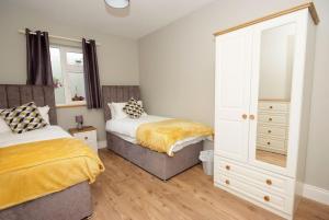sypialnia z 2 łóżkami i komodą w obiekcie Kerry Air w Killarney