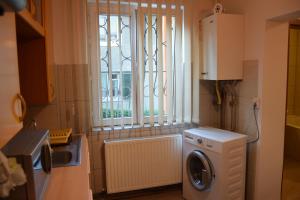 a kitchen with a washing machine and a window at Central Appartment St's Martin Church in Braşov