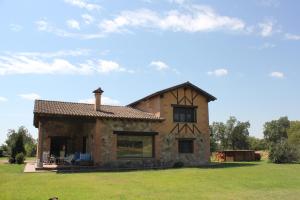 a small stone house with a roof on a field at Casa Valentina in Candeleda