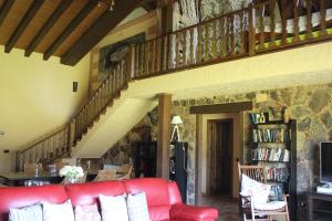a living room with a red couch and a staircase at Casa Valentina in Candeleda
