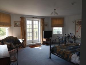 1 dormitorio con 1 cama, mesa y sillas en The Weir Hotel, en Walton-on-Thames