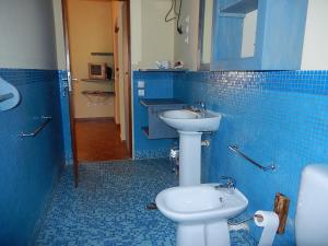 a blue tiled bathroom with a sink and a toilet at Residenz Stella Maris Apartment Strela in Calheta Do Maio