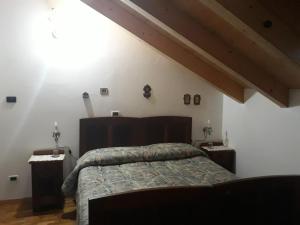 a bedroom with a bed and two night stands at Aprt Val di Fiemme - Molina in Castello di Fiemme