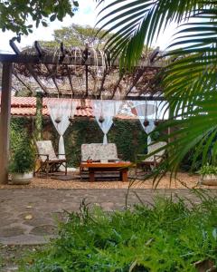 a patio with two chairs and a table and a pergola at Pousada Sombra do Cajueiro in Alter do Chao