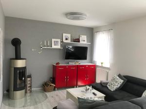 a living room with a black couch and a red cabinet at Haus Seewind Hohenfelden in Hohenfelden