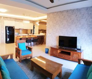 a living room with a television and a couch and a table at Meridin in Nusajaya