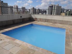 a blue swimming pool on the roof of a building at Residencial Genéve in Sao Paulo