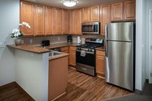 a kitchen with a refrigerator, stove, sink and microwave at Tahiti All-Suite Resort in Las Vegas