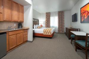 a hotel room with a bed and a kitchen at Tahiti All-Suite Resort in Las Vegas