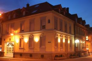 a large white building at night with lights at Schinderhannes in Waibstadt