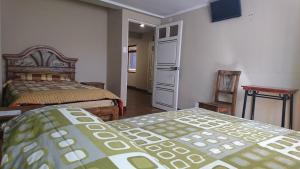 a bedroom with two twin beds and a refrigerator at Bolivian Heights Hostel in La Paz