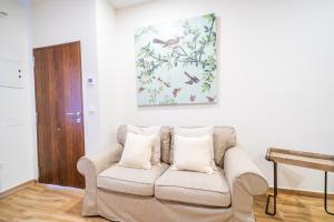 una sala de estar con sofá y una pintura en la pared en A&S APARTAMENTOS MALAGA I en Málaga